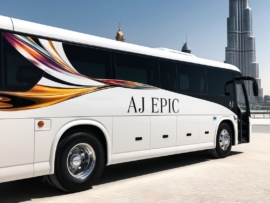 Stylish white Mercedes bus featuring "AJ EPIC" branding parked under the clear blue sky near Burj Khalifa.